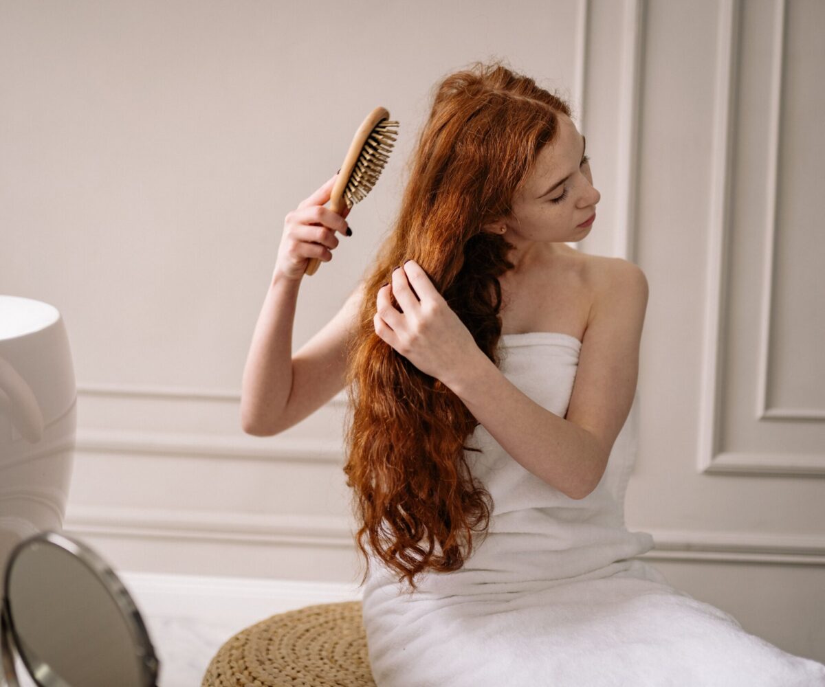 Mulher com cabelo saudável e cheiroso após rotina de cuidados capilares